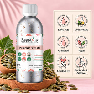 A bottle of Raasa oils Pumpkin Seed Oil stands on a wooden tray surrounded by pumpkin seeds, with a pink fabric backdrop and a product information panel to the right highlighting features like 100% pure, cold pressed, undiluted, vegan, cruelty free, and no synthetic additives.