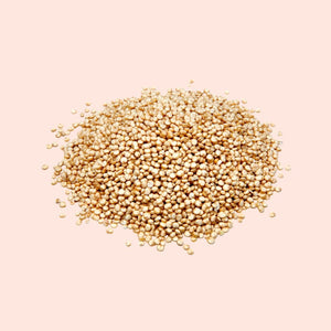 Heap of quinoa seeds on a light pink background