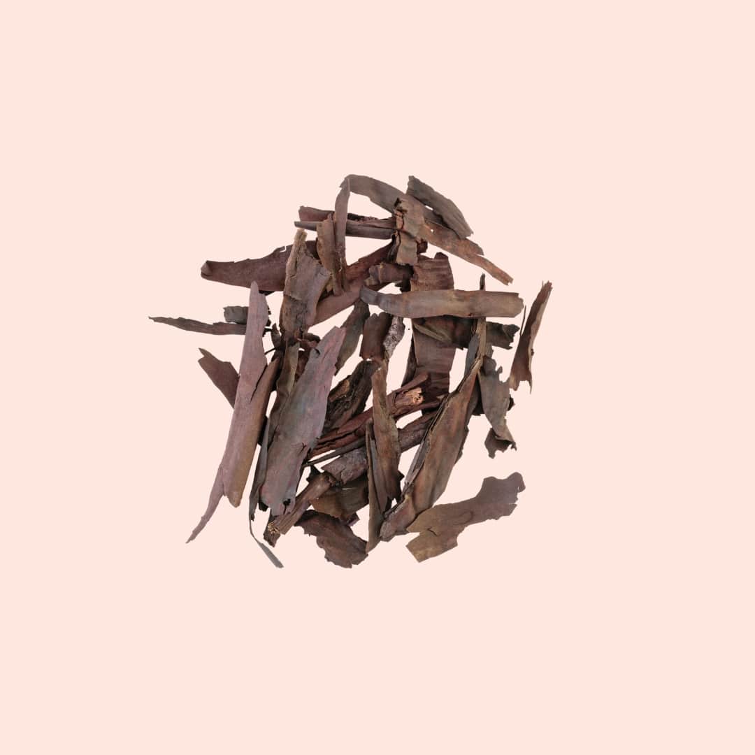 Stack of dried brown leaves on a light pink background