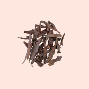 Stack of dried brown leaves on a light pink background
