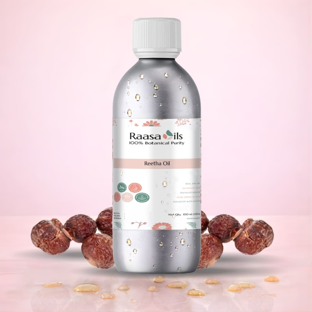 Bottle of Raasa Oils Reetha Oil with ingredients on a pink background