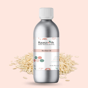 Bottle of Raasa Oils Rice Bran Oil with rice grains on a light pink background