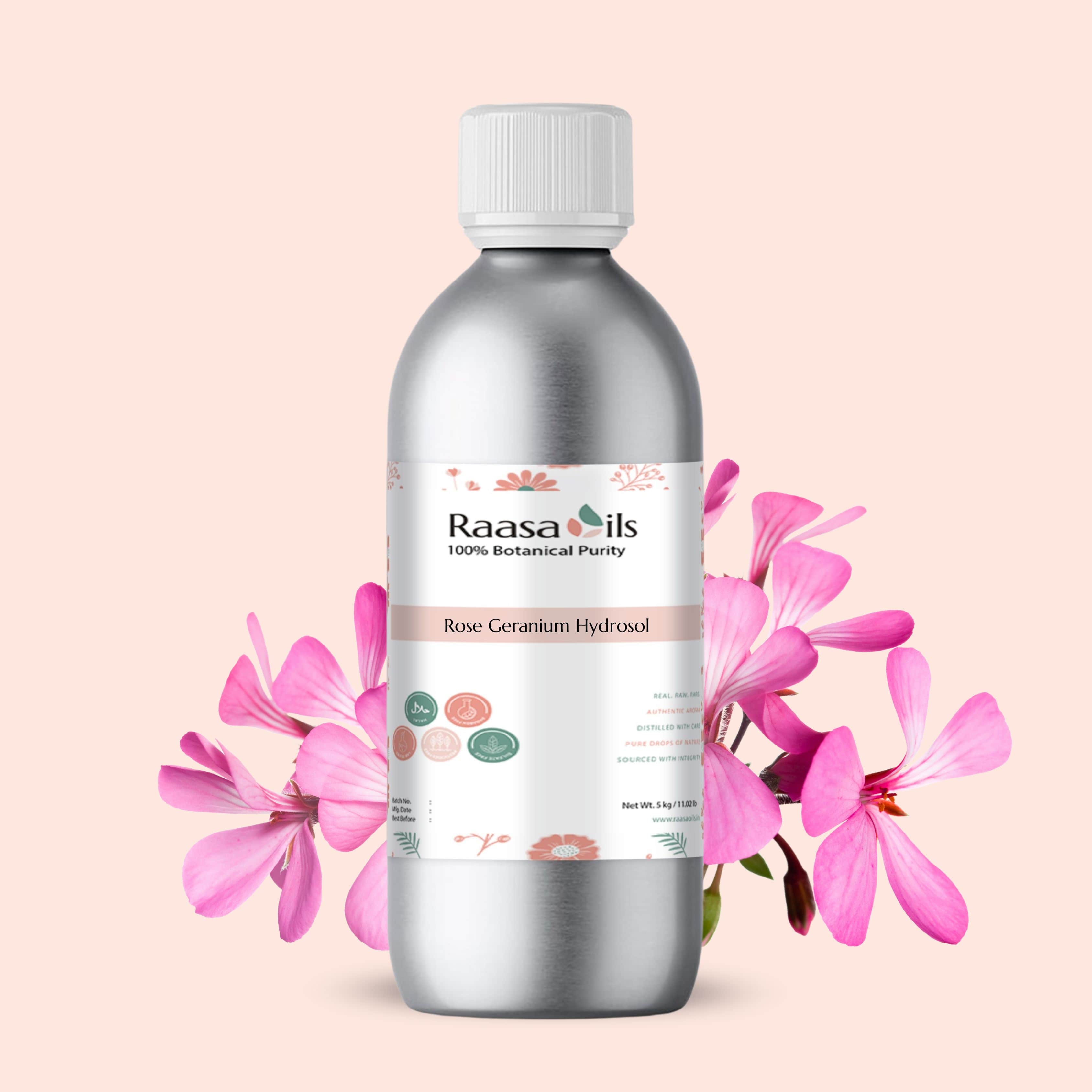 Bottle of Raasa Oils Rose Geranium Hydrosol with pink flowers on a light pink background