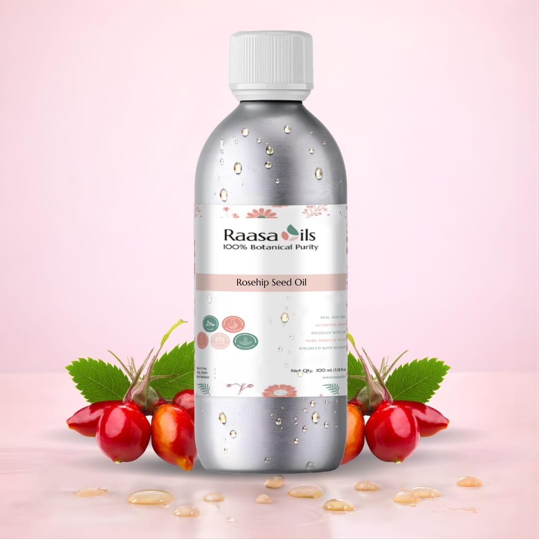 Bottle of Raasa Oils Rosehip Carrier Oil with rosehip fruit and leaves on a light pink background