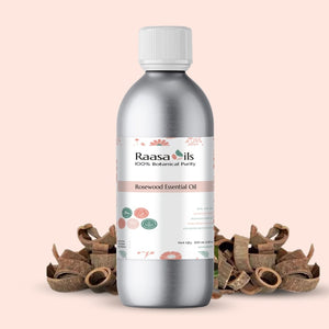 Bottle of Raasa Oils Rosewood Essential Oil on a beige background with rosewood pieces.