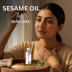 Woman applying sesame oil to her face with a dropper, surrounded by sesame seeds and leaves on a wooden tray.