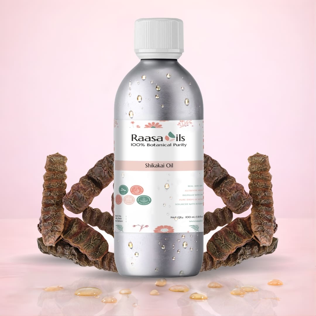 Bottle of Raasa Oils Shikakai Oil with dried shikakai roots on a pink background
