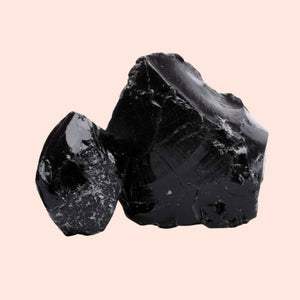 Two dark stones on a light pink background