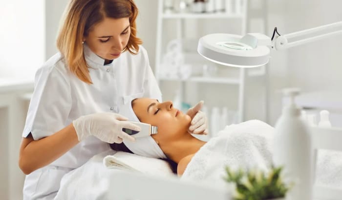 Woman receiving a facial treatment in a clinical setting.