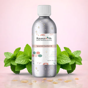 Spearmint essential oil bottle with leaves on a pink background