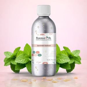 Spearmint hydrosol bottle with spearmint leaves on a pink background