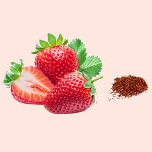 Strawberries with a small pile of dark brown powder on a light pink background
