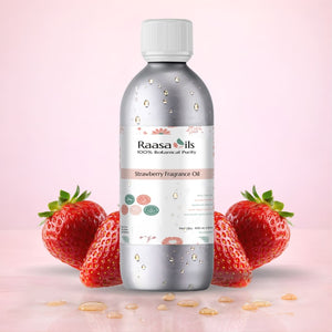 Bottle of Raasa Oils Strawberry Fragrance Oil with strawberries on a pink background