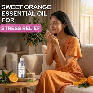 Woman in an orange dress sitting on a couch with sweet orange essential oil for stress relief.