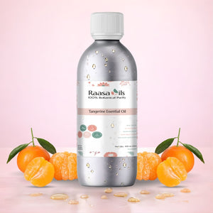 Bottle of Raasa Oils Tangerine Essential Oil with tangerines and leaves on a light pink background