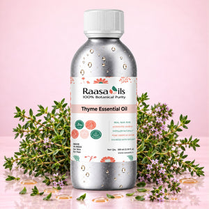 A bottle of Raasa oils Thyme Essential Oil centered on a pink background, surrounded by fresh thyme sprigs, flowers, and scattered gold droplets. The bottle is metallic silver with a white cap and a white label featuring pink, green, and orange accents.