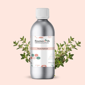 Bottle of Raasa Oils Thyme Hydrosol with green leaves on a light pink background