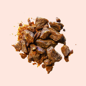 Heap of brown resinous material on a beige background