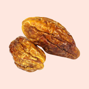Two dried dates on a beige background