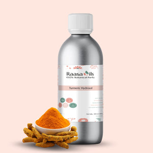 Bottle of Raasa Oils Turmeric Hydrosol with turmeric powder and roots on a light pink background