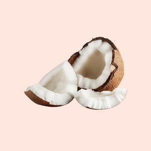 Split coconut on a light pink background
