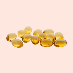 Yellow capsules on a light pink background