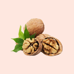 Walnuts with green leaves on a pink background