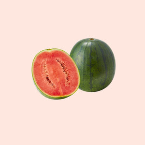 Whole and half watermelon on a light pink background