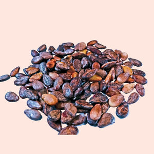 Pile of dark brown flaxseeds on a beige background