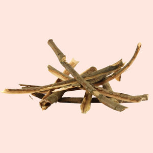 Stack of dried plant sticks on a pink background