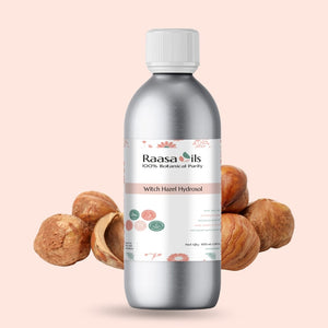 Bottle of Raasa Oils Witch Hazel Hydrosol with witch hazel nuts on a beige background
