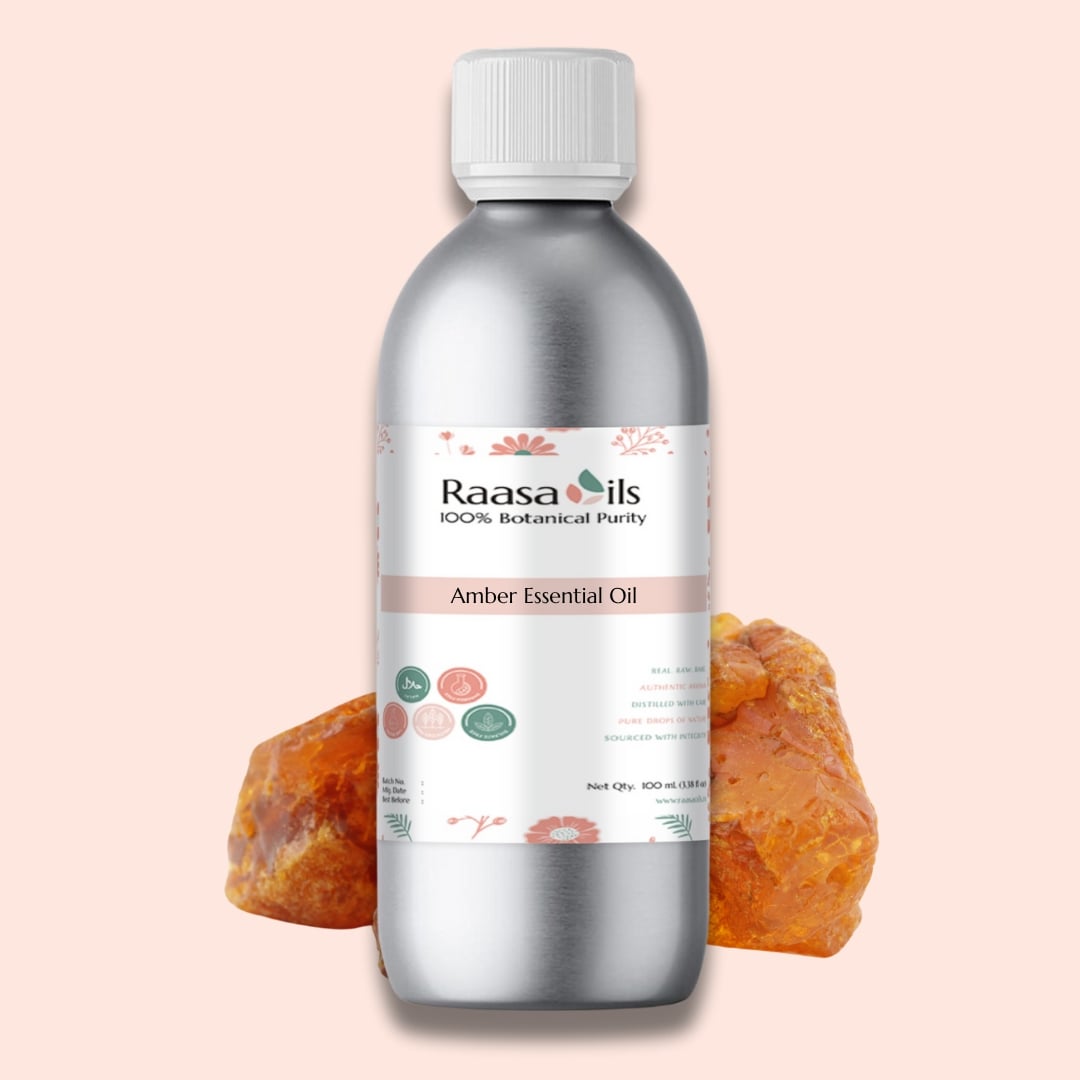 Raasa Oils Amber Essential Oil bottle with amber stones on a light pink background