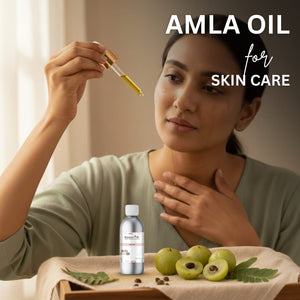 Woman holding a dropper with Amla oil and Amla berries on a table.