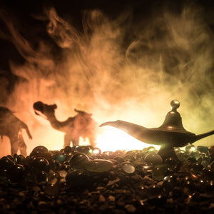 Aladdin's magic lamp with smoke and desert scene in the background