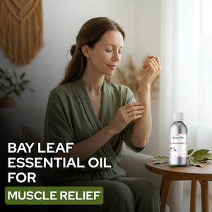 Woman applying Bay Leaf Essential Oil to her arm with a bottle of the product on a table.