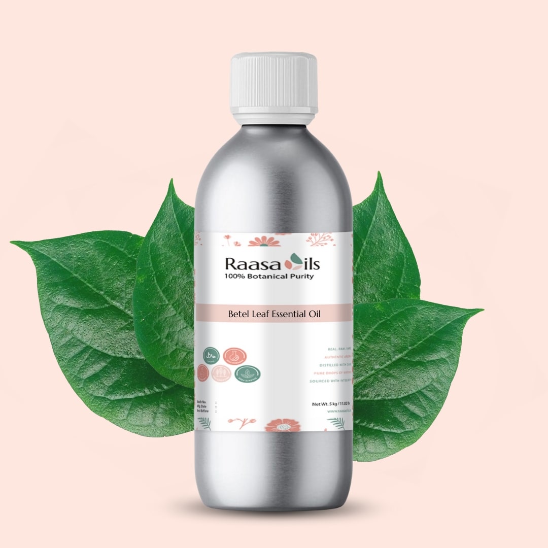Bottle of Raasa Oils Betel Leaf Essential Oil with green leaves on a light pink background