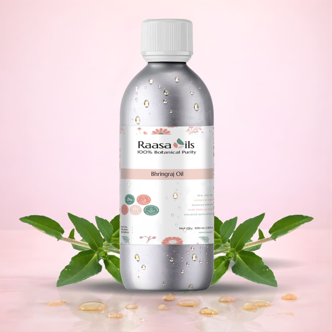 Bottle of Raasa Oils with green leaves on a pink background