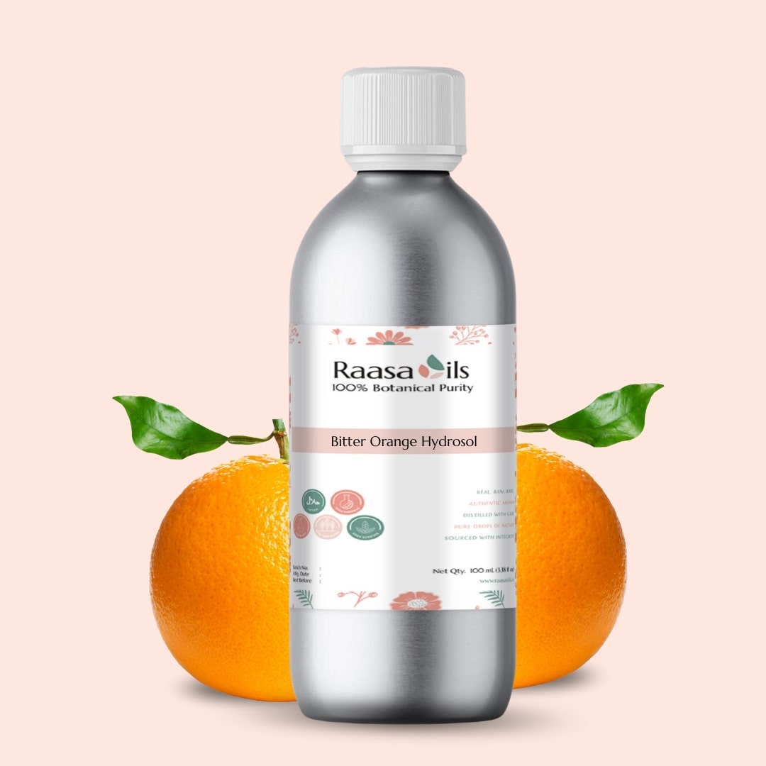 Bottle of Raasa Oils Bitter Orange Hydrosol with oranges on a light pink background