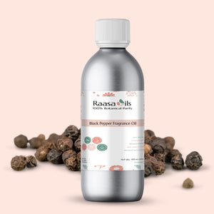 Bottle of Raasa Oils Black Pepper Fragrance Oil with black pepper seeds on a beige background