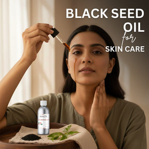 Woman applying black seed oil to her face with a dropper, surrounded by black seed and leaves on a wooden tray.