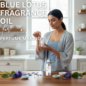 Woman holding a bottle of Blue Lotus fragrance oil in a kitchen setting with flowers and containers on the table.