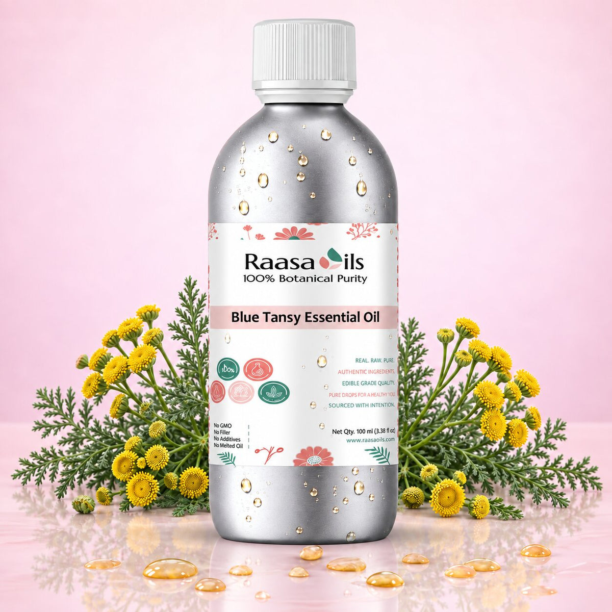 A bottle of Raasa Oils Blue Tansy Essential Oil centered on a pink background, flanked by green tansy stems and small yellow flowers. The bottle is metallic silver with a white cap and a white label featuring pink and green botanical illustrations.