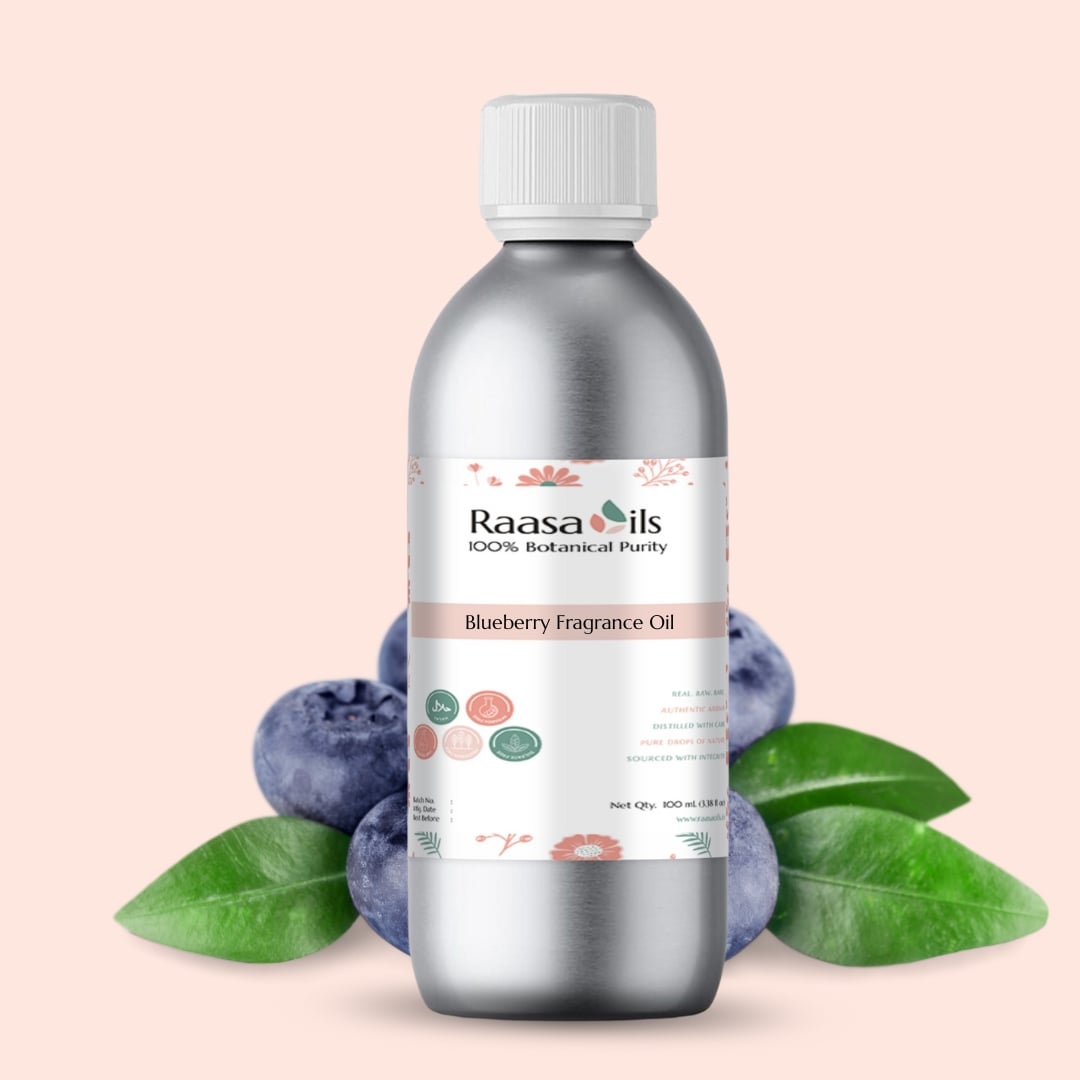 Bottle of Raasa Oils Blueberry Fragrance Oil with blueberries and leaves on a light pink background