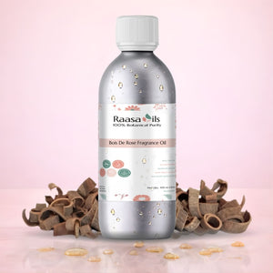 Bottle of Raasa Oils Bois De Rose Fragrance Oil on a pink background with cinnamon sticks.