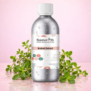 A bottle of Raasa Oils Brahmi Extract centered on a pink background, surrounded by green herbal sprigs and water droplets. The bottle is metallic silver with a white cap and a white label featuring pink and green accents.