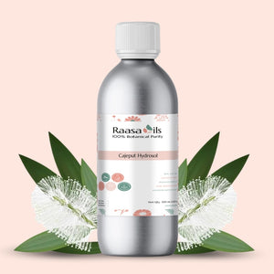 Bottle of Raasa Oils Cajuput Hydrofol with leaves on a light pink background
