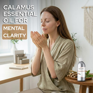 Woman meditating with a bottle of Calamus essential oil on a table.