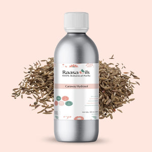 Raasa Oils caraway hydrosol bottle with caraway seeds on a light pink background