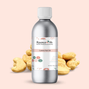 Bottle of Raasa Oils Cashew Nut Oil with cashew nuts on a light pink background
