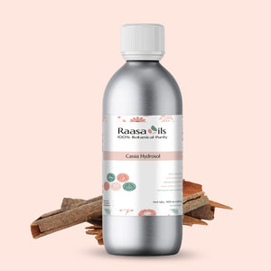 Bottle of Raasa Oils Cassia Hydrosol with cinnamon sticks on a beige background
